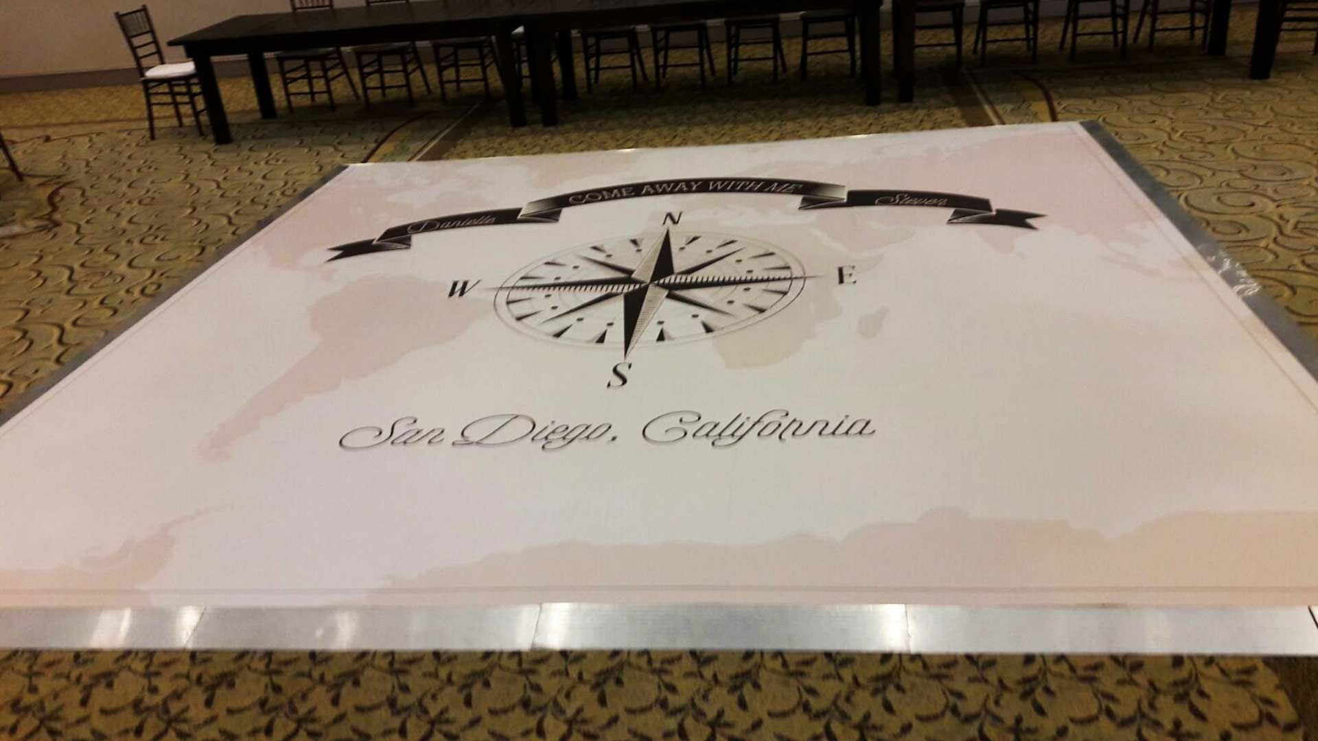 A dance floor in San Diego, California, featuring a vintage map, a compass rose, and a decorative banner design.