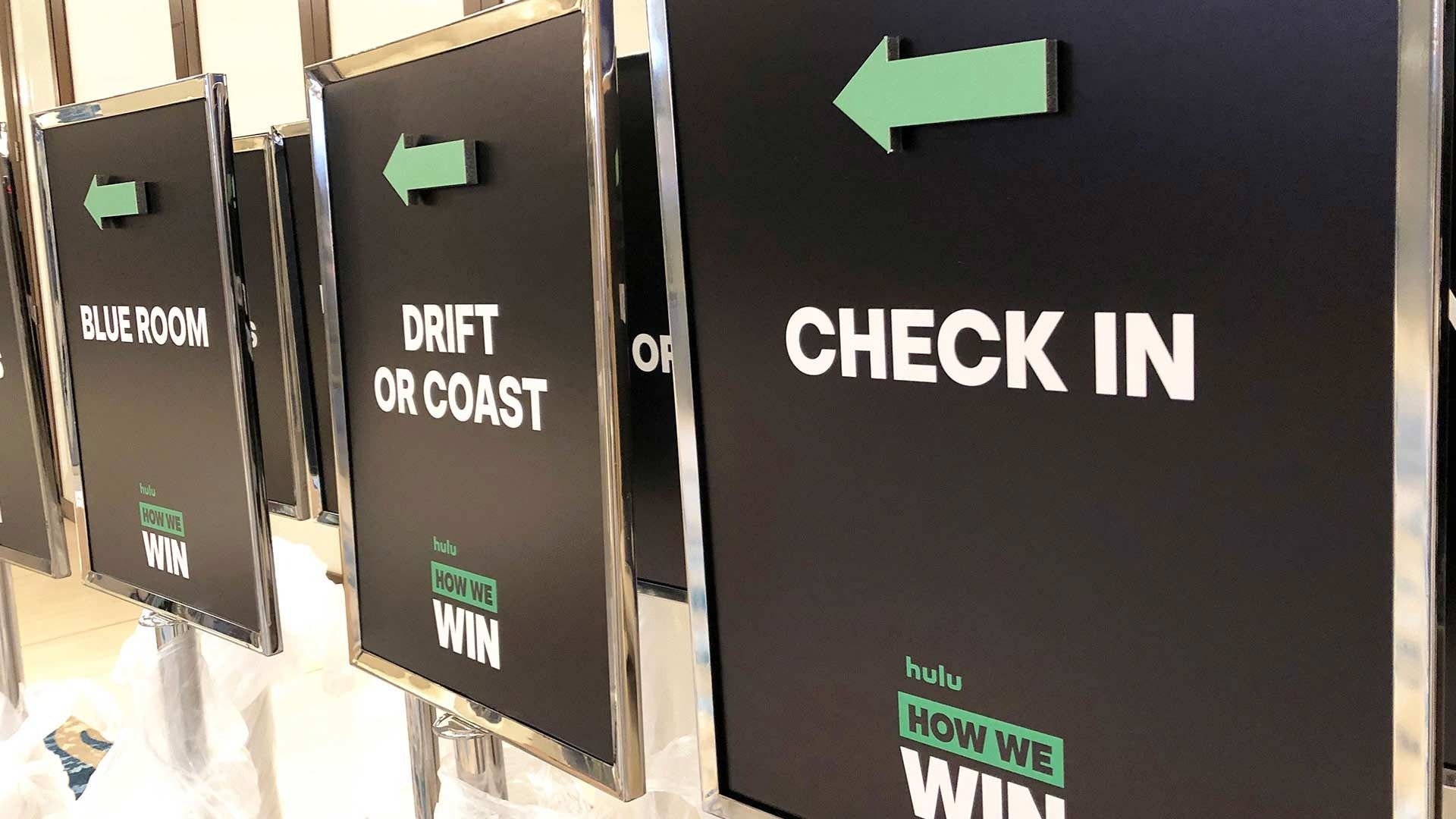 A row of black signs with green arrows and text reading 