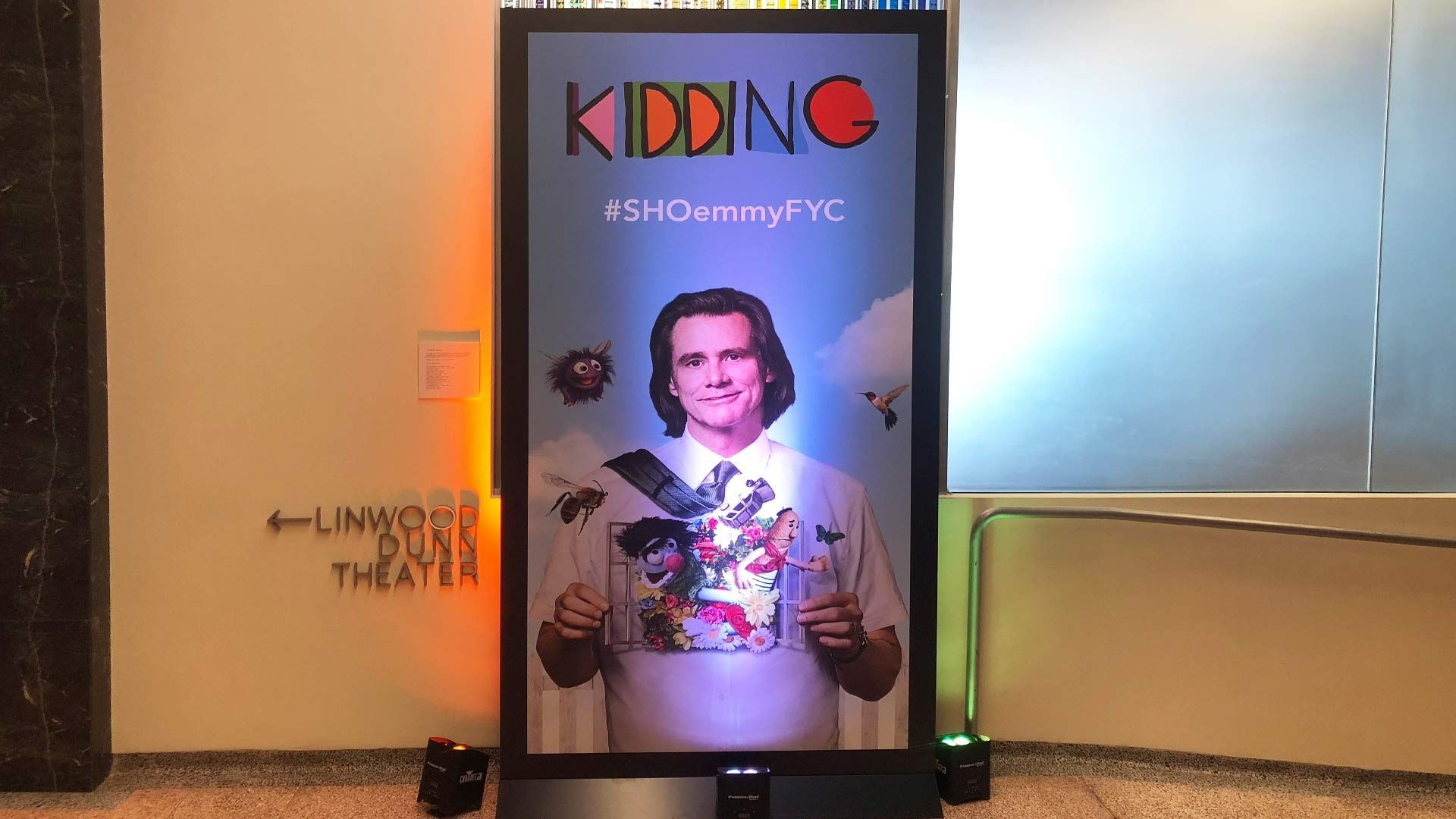 A digital display shows a promotional poster for the TV show 