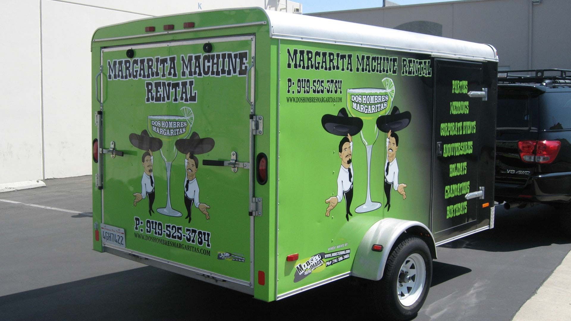 A green rental trailer parked outdoors, branded with 