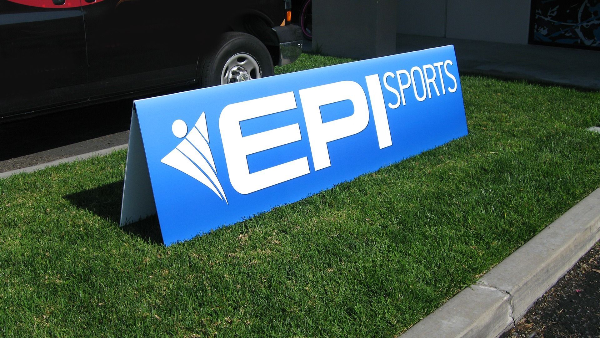 A blue A-frame sign with the white logo and text 