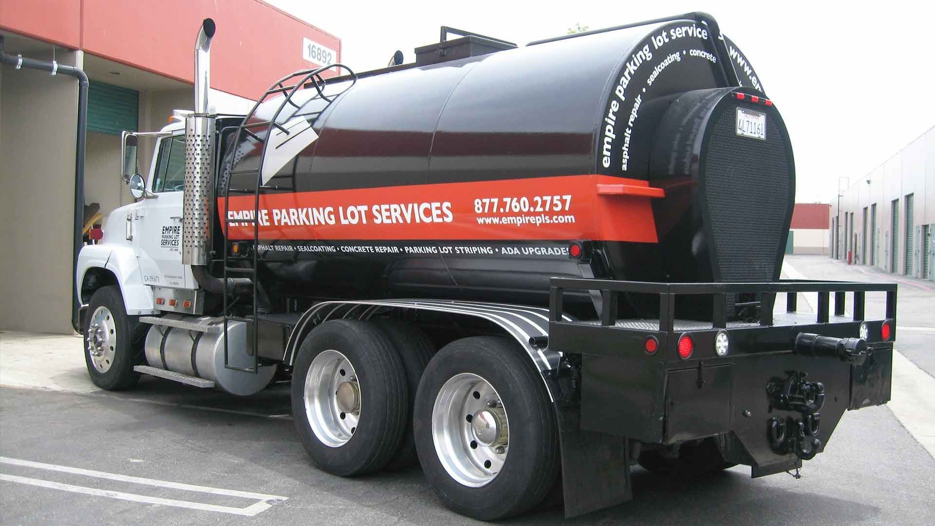 A white, black, and orange tanker truck labeled 