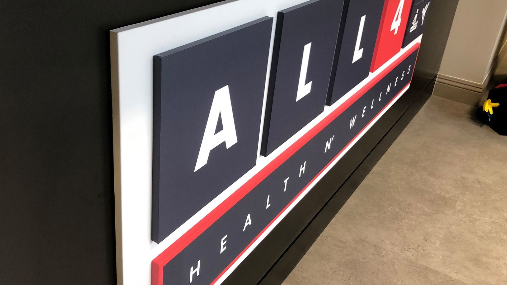 An angled close-up of a dimensional sign on a black wall reading 