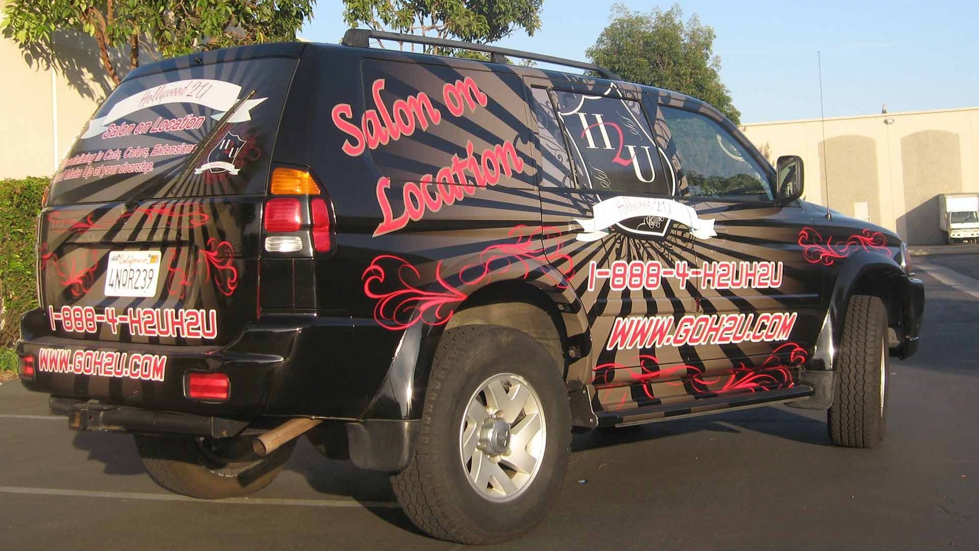 A black SUV parked outdoors, featuring a starburst graphic, 