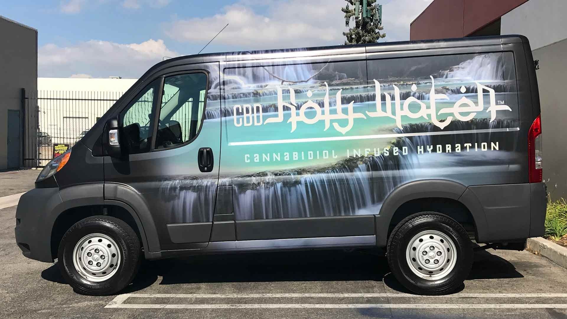 A side view of a black van featuring a branded wrap for 