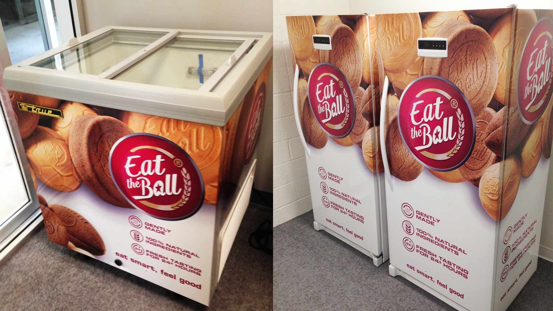 Three Eat the Ball branded refrigeration units featuring bread-themed graphics stand in an indoor setting.