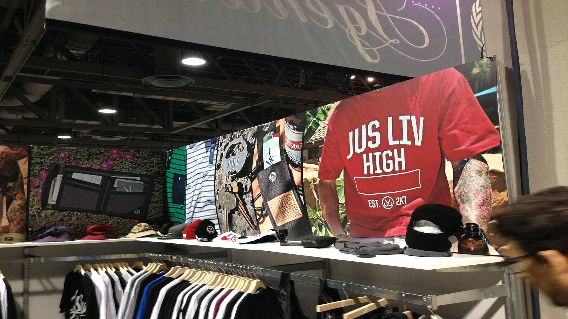 Clothing display at a trade show booth featuring a large red t-shirt with 