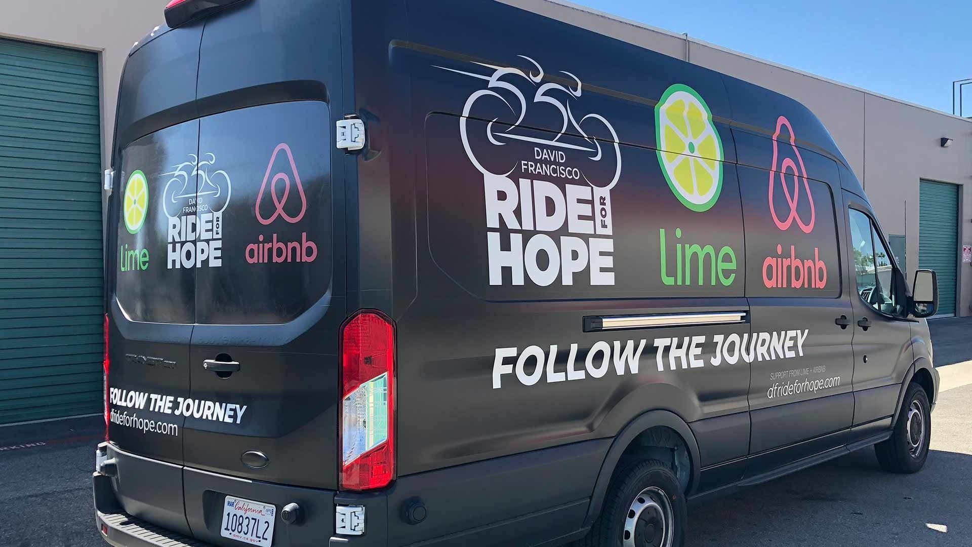 A black cargo van branded with 