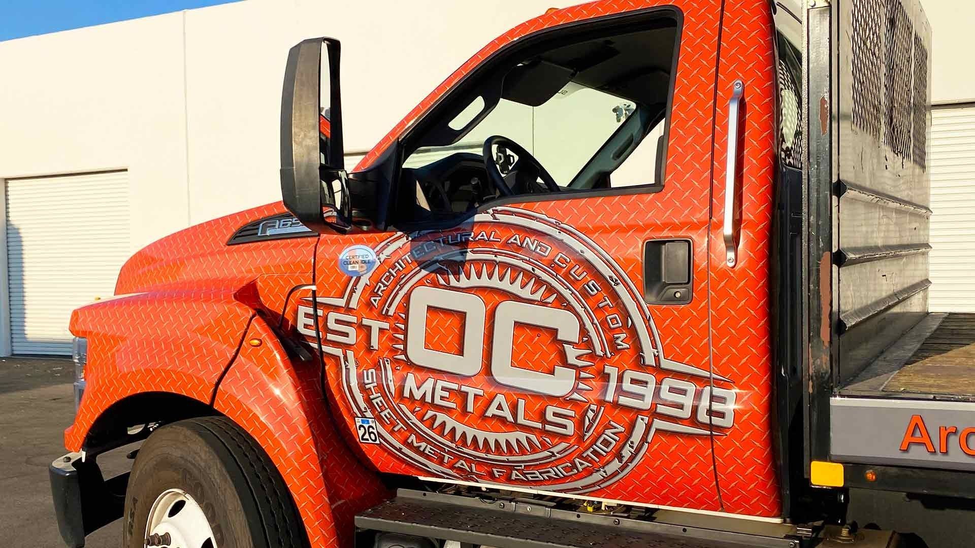 An orange truck with a diamond plate exterior features the 