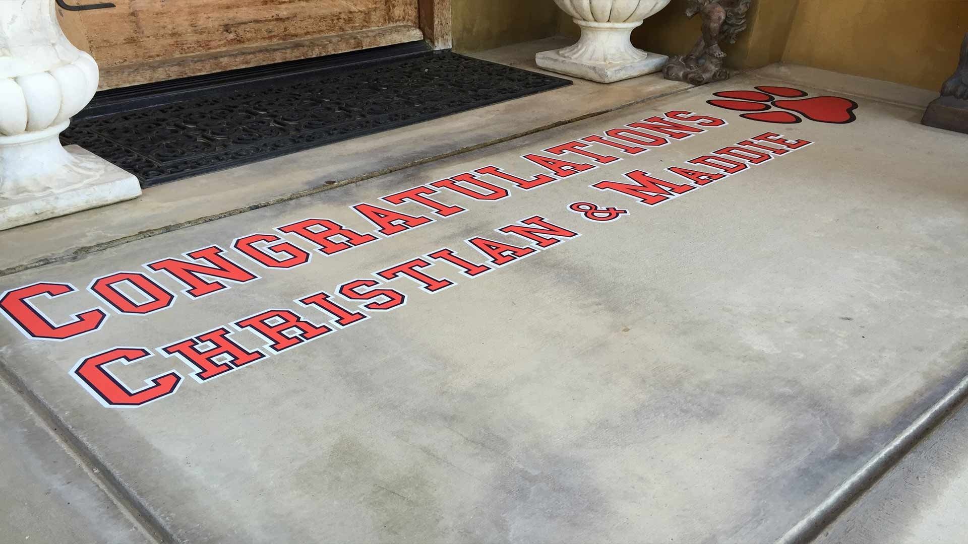 Red block-letter text on a concrete porch reading 