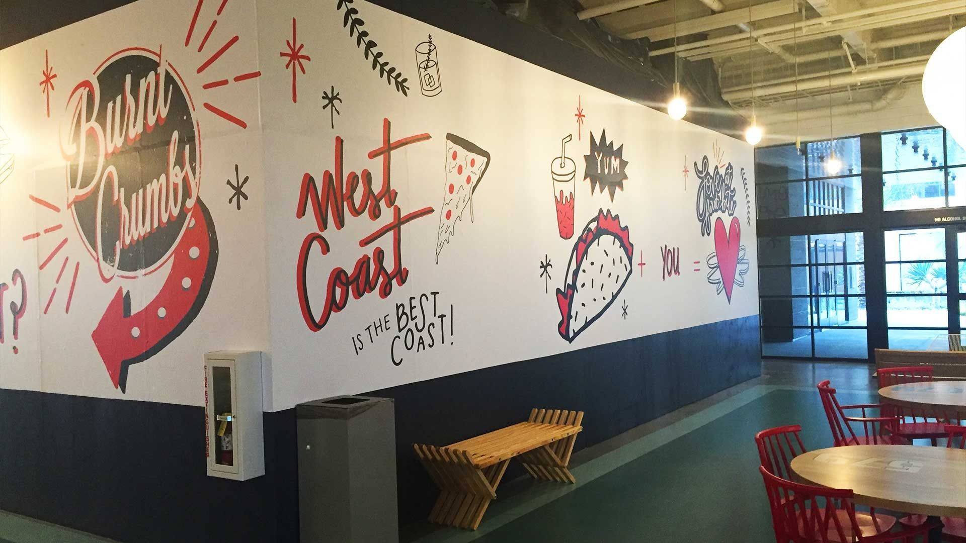 A wall decorated with food-themed illustrations and text reading 