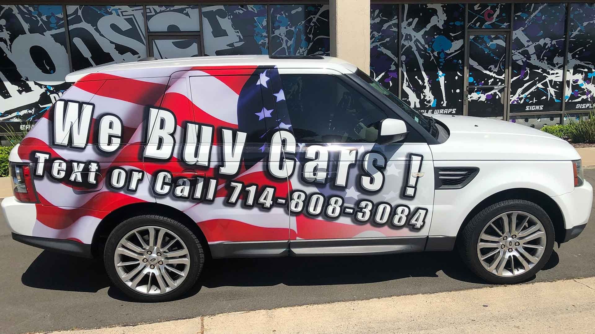 A white SUV wrapped in an American flag design with the text 