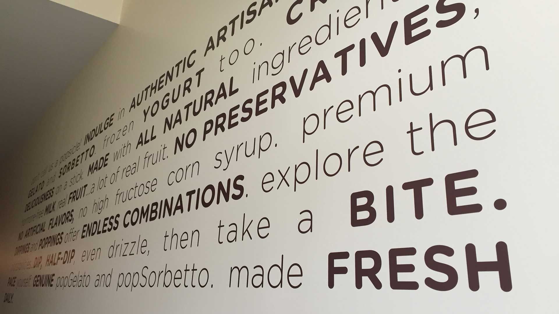 A wall with brown, sans-serif text detailing product benefits like 