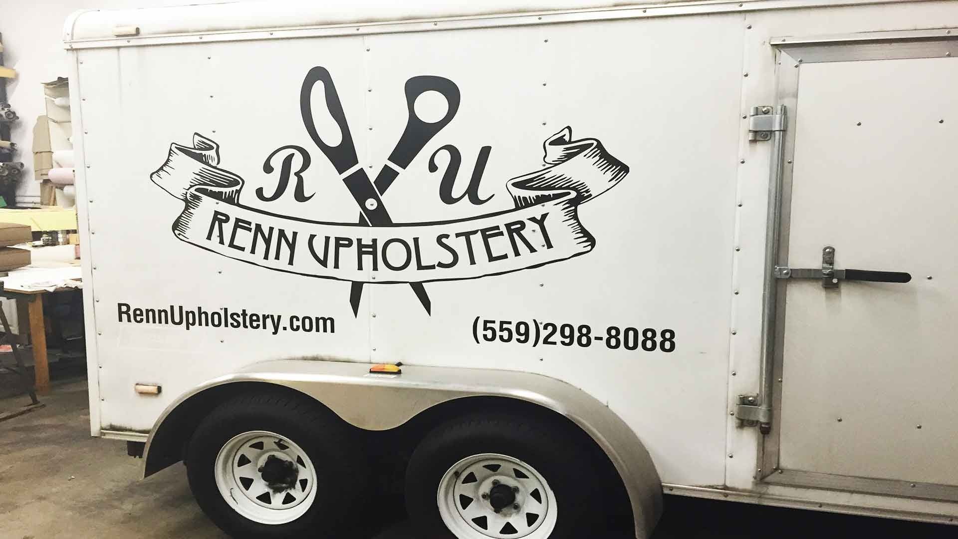 White utility trailer with the Renn Upholstery logo, website, and phone number on the side.