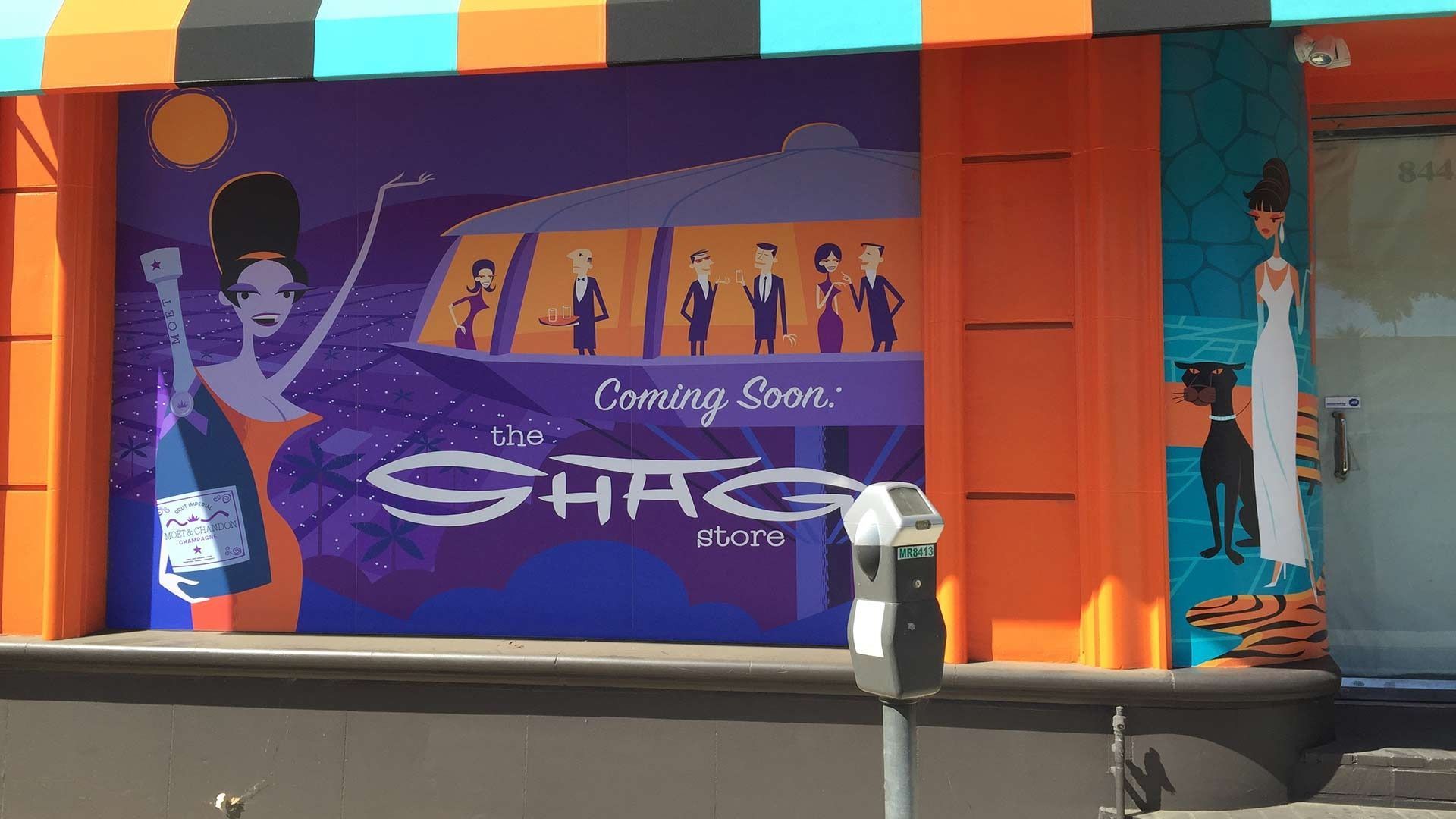 A storefront mural features Mid-century modern style figures, orange trim, and the text 