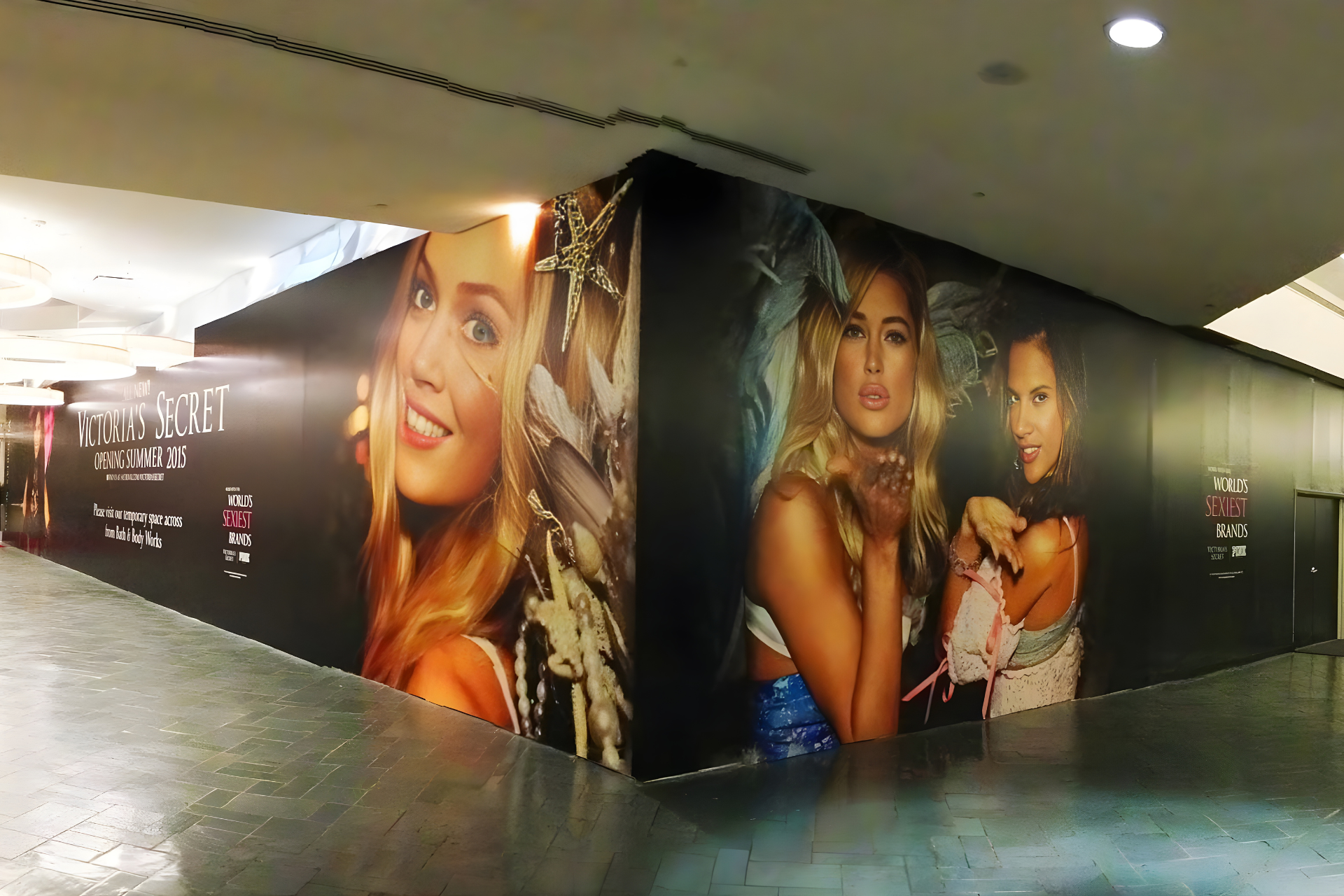 A large-scale wall mural of a brightly lit city skyline at sunset, with tall skyscrapers and urban buildings.