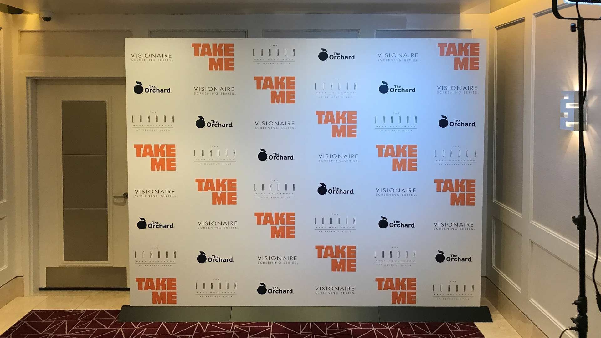 A white step-and-repeat banner with repeating 