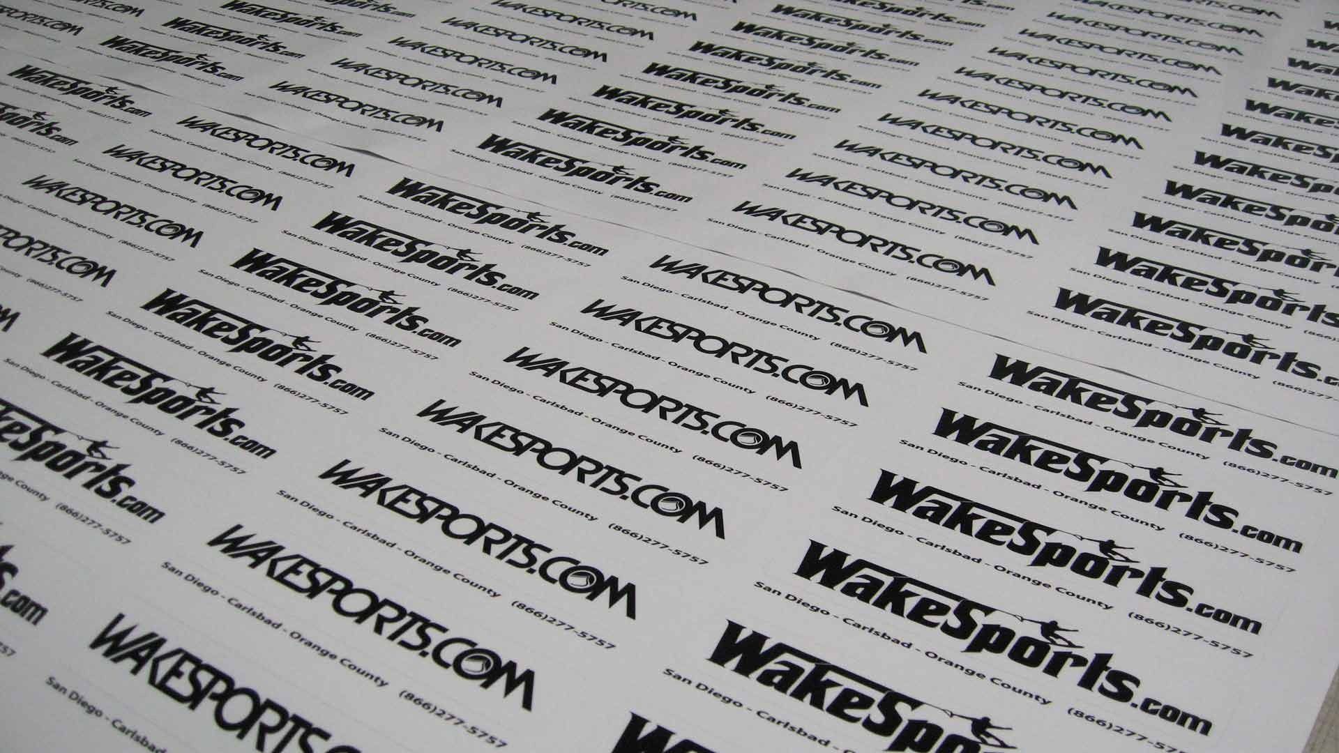 A sheet of white adhesive stickers, each featuring the black logo and web address for 