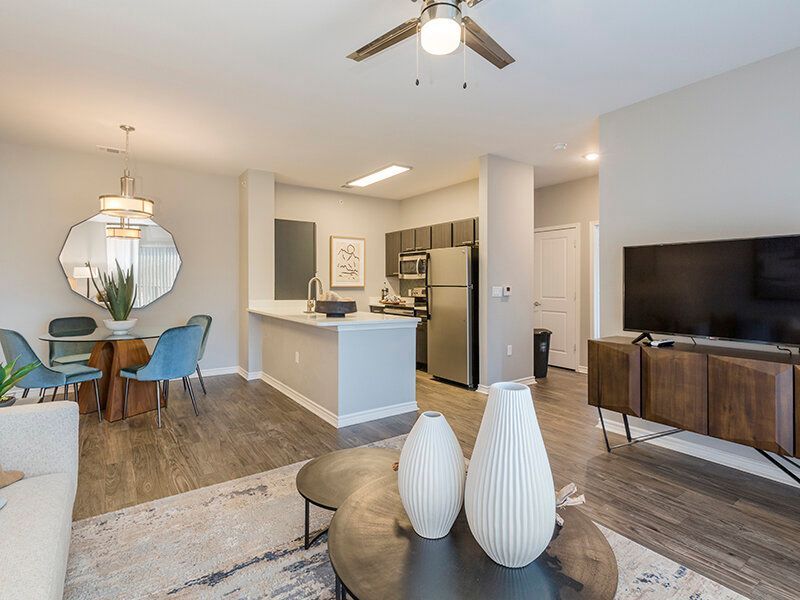 Open-concept living area with kitchen, dining table, couch, and TV.