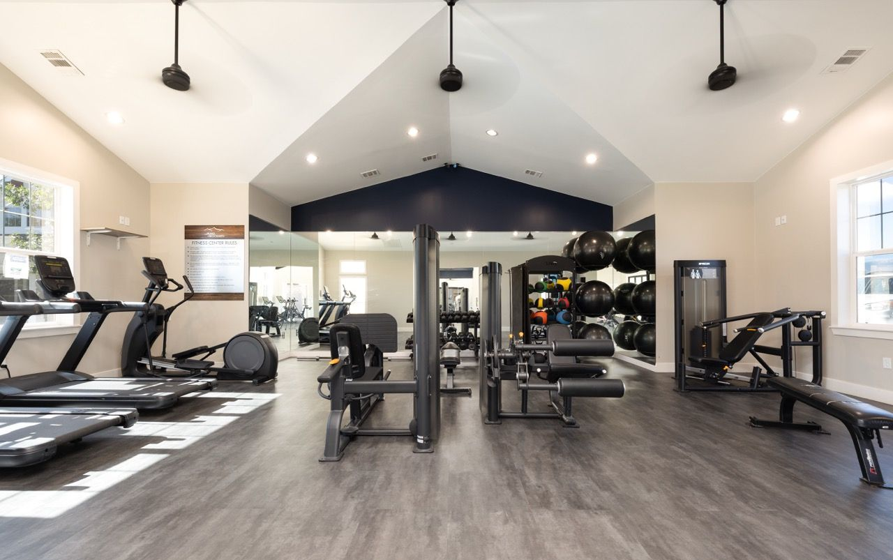 Interior fitness center with treadmills, weight machines, free weights, and benches.
