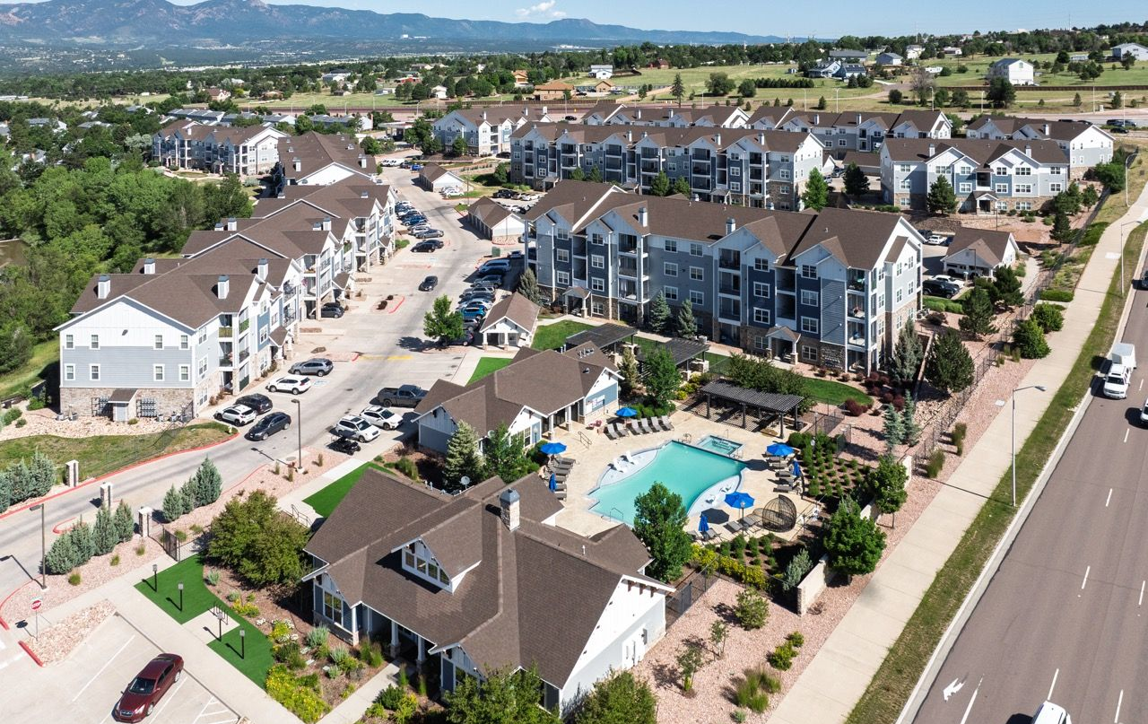 Aerial view of a multifamily community with buildings around a central pool.