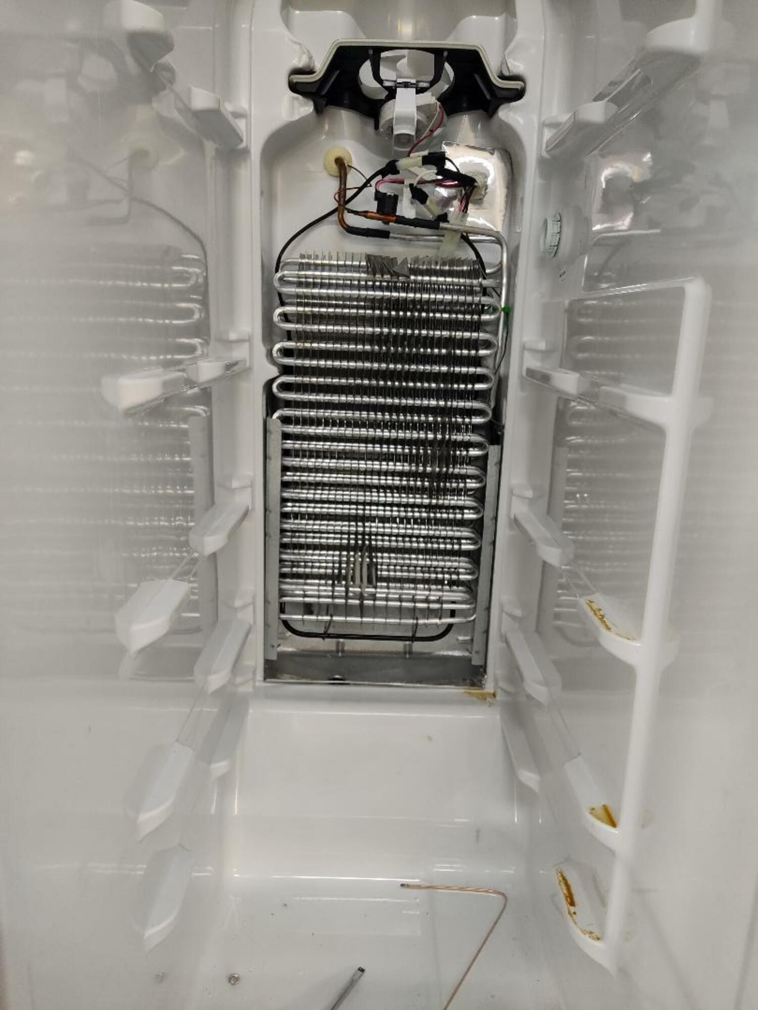 The inside of an empty refrigerator with the door open.