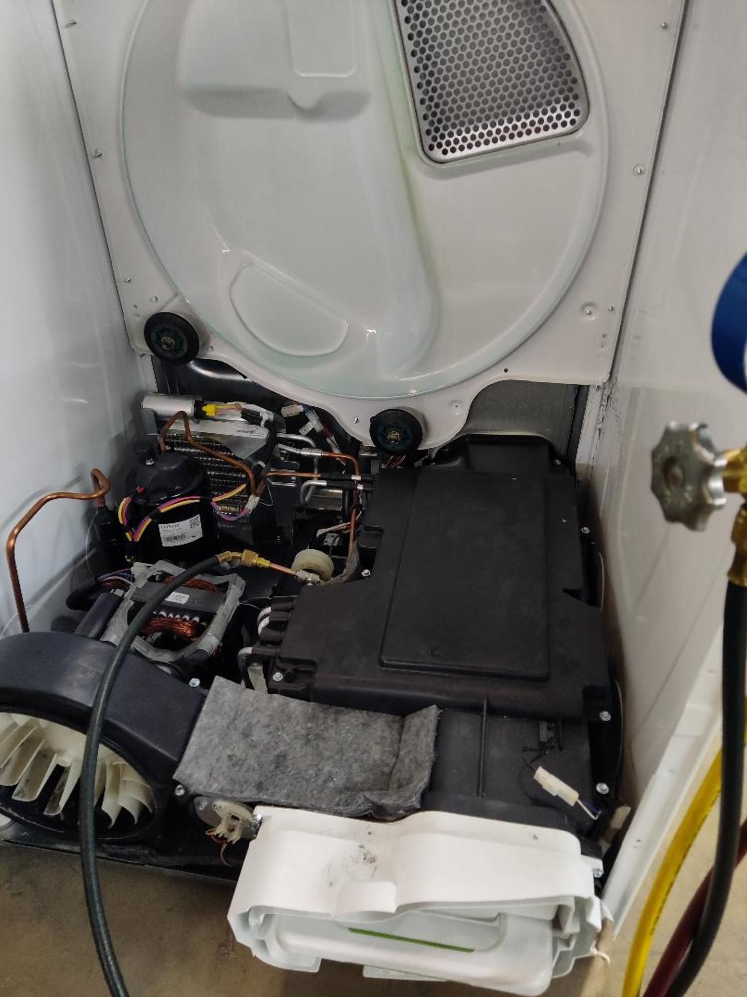 The inside of a washer and dryer is being repaired.