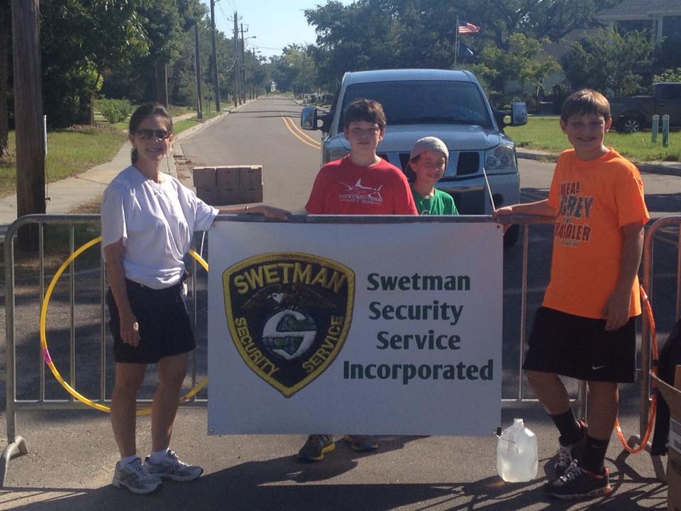 People Holding Swetman Security Service Banner — Biloxi, MS — Swetman Security Service Incorporated — Biloxi, MS — Swetman Security Service Incorporated