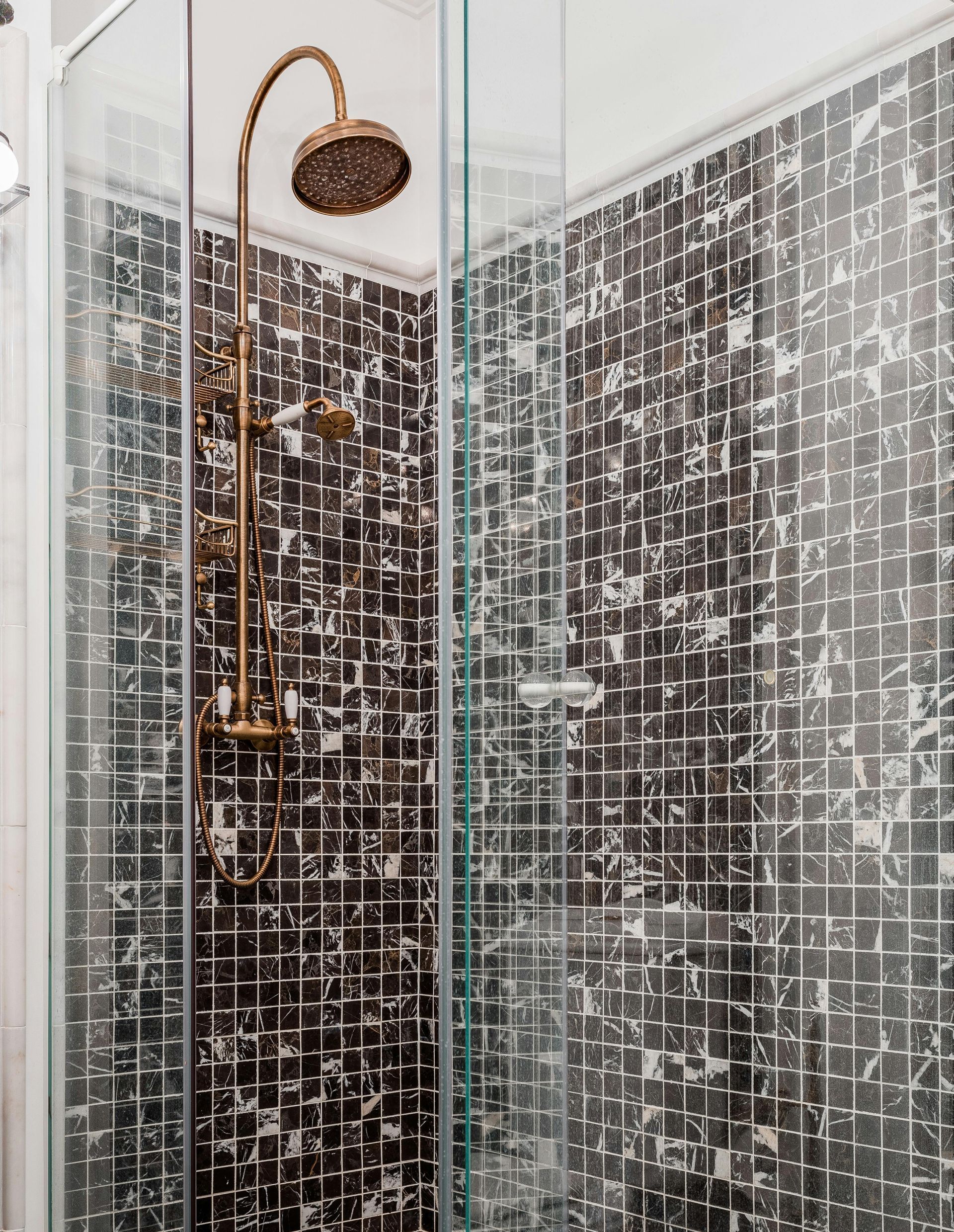 A creative tiled bathroom with marble effect wall tiles in the shower