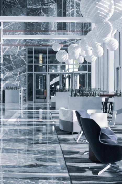 A large marble-tiled lobby with a lot of chairs and tables