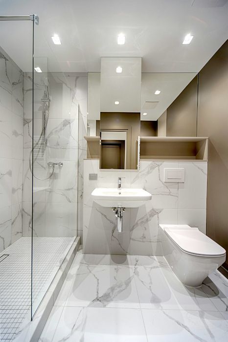 A bathroom with a sink , toilet , shower and mirror. Shower expertly sealed by Rose Tiling in Stoke-on-Trent.