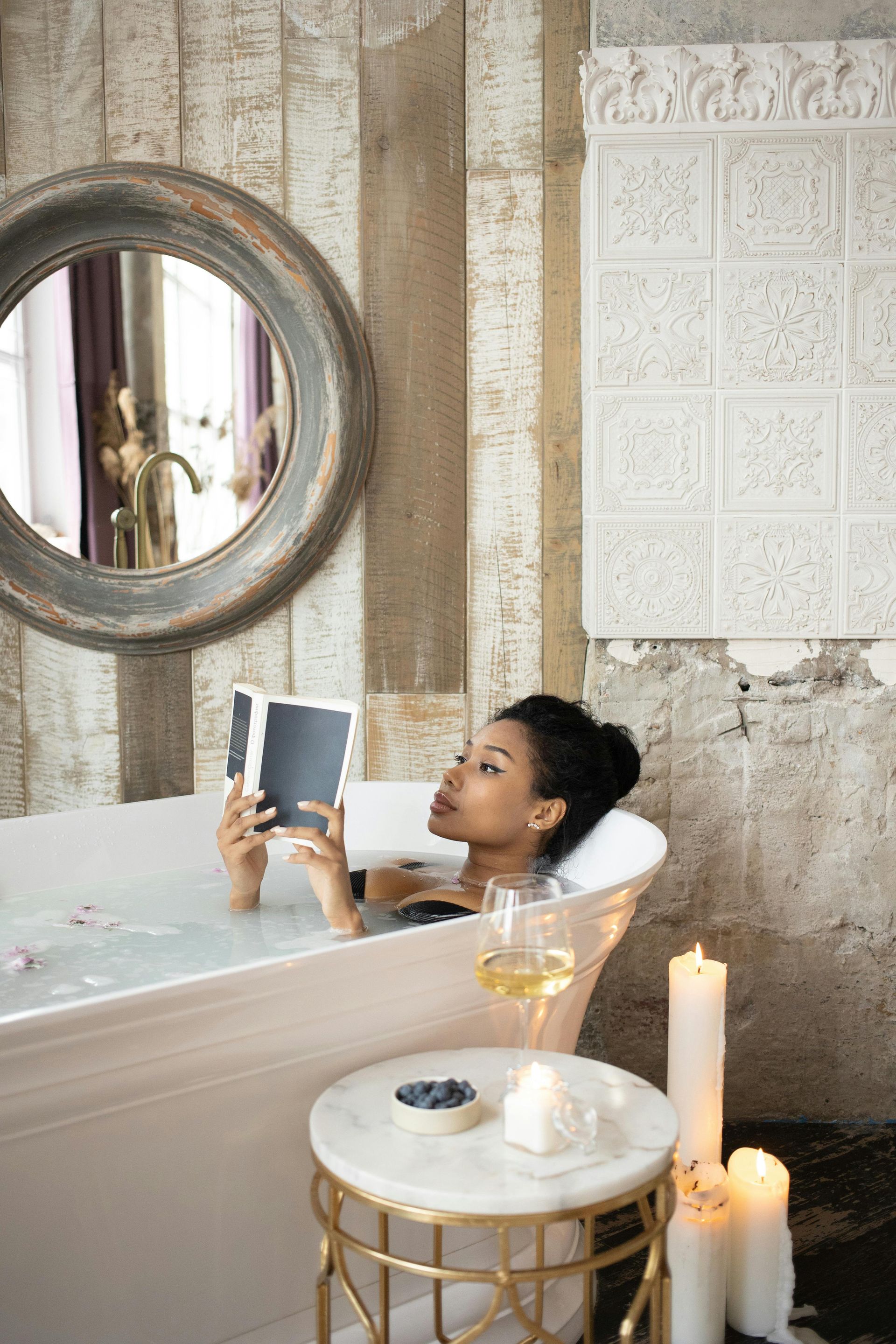 Bathroom in Meditteranean style with a lady reading in a bath