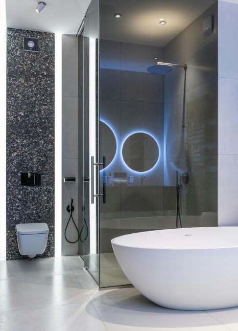 A bathroom with a bathtub and a toilet. Expertly tiled by Rose Tiling in Stoke-on-Trent, UK.