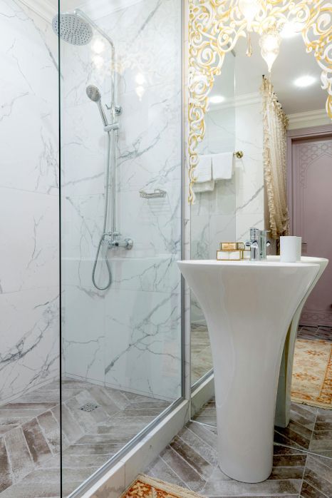 A bathroom with a sink and a walk in shower. Shower expertly sealed by Rose Tiling in Stoke-on-Trent.