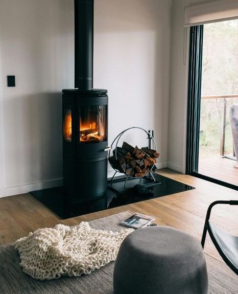 A living room with a wood stove and a sliding glass door.