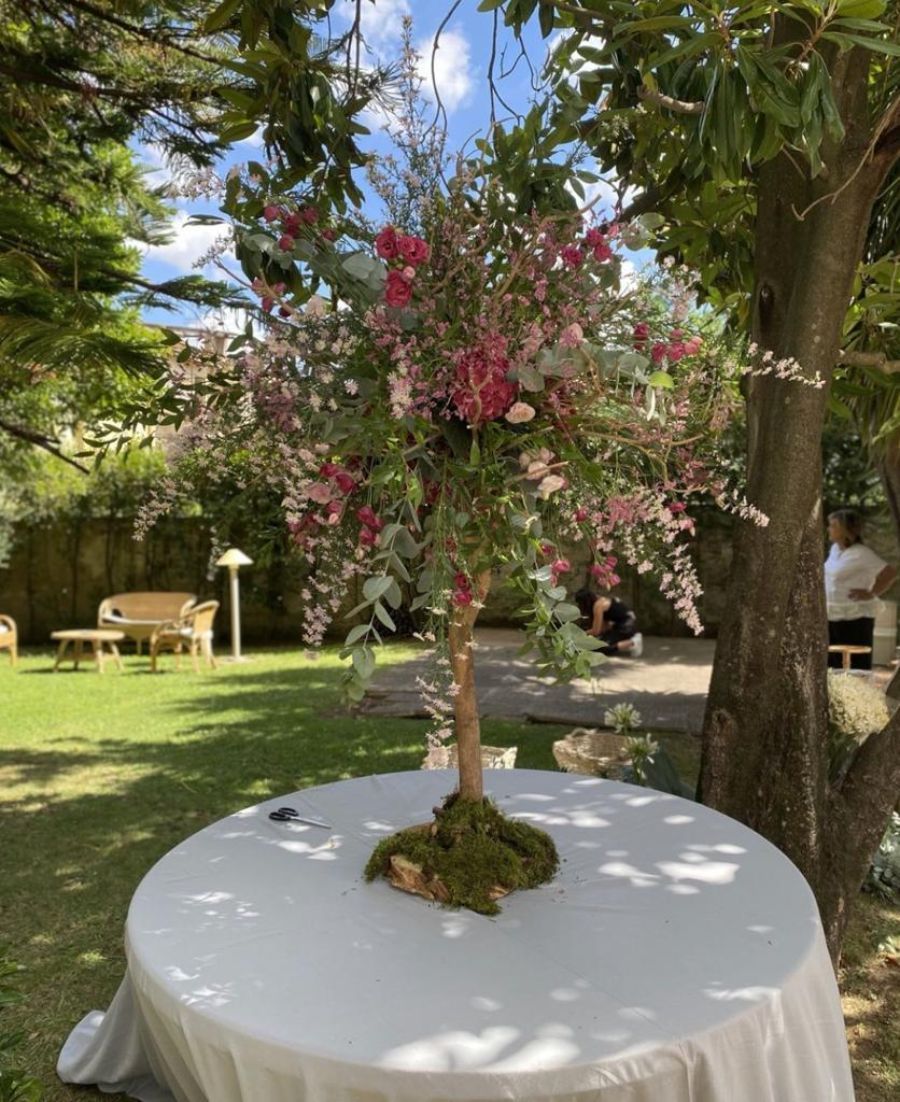 alberello con fiori rosa al centro di un tavolo tondo
