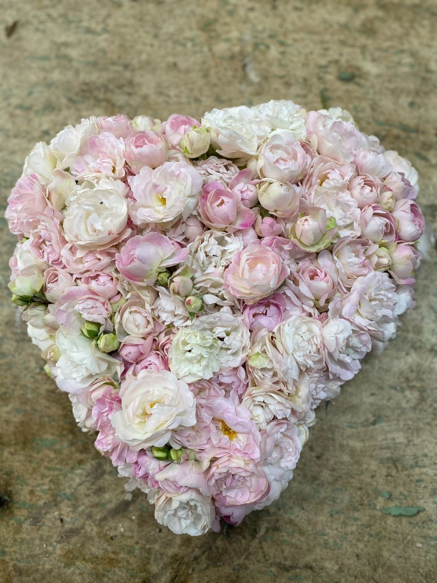 composizione di fiori rosa e bianchi a forma di cuore