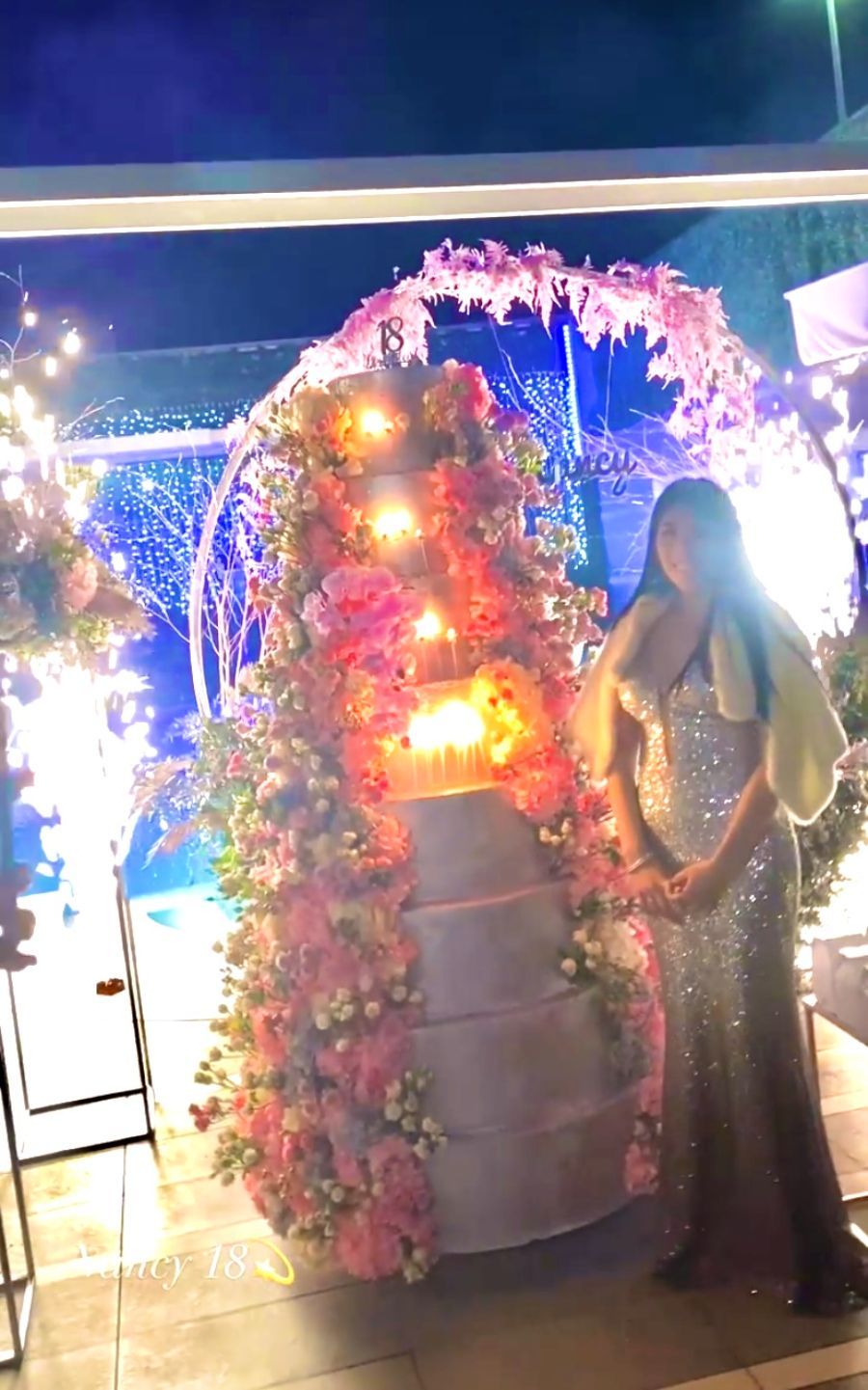 festeggiata vicino a torta con decorazione floreale