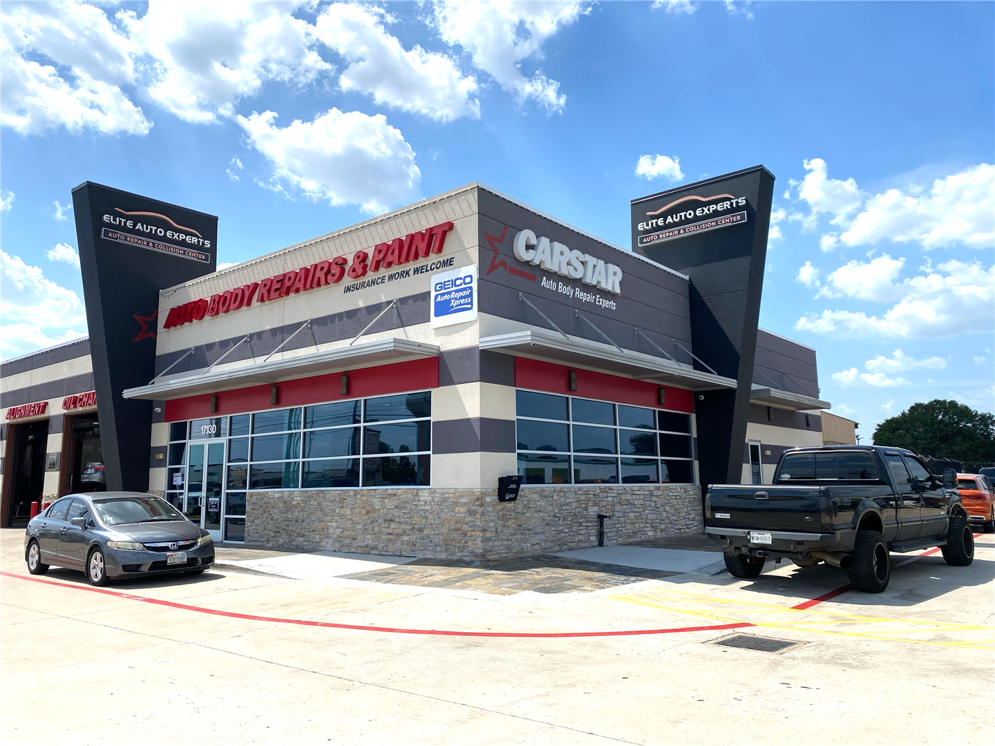 Two cars are parked in front of a car dealership. | Elite Auto Experts