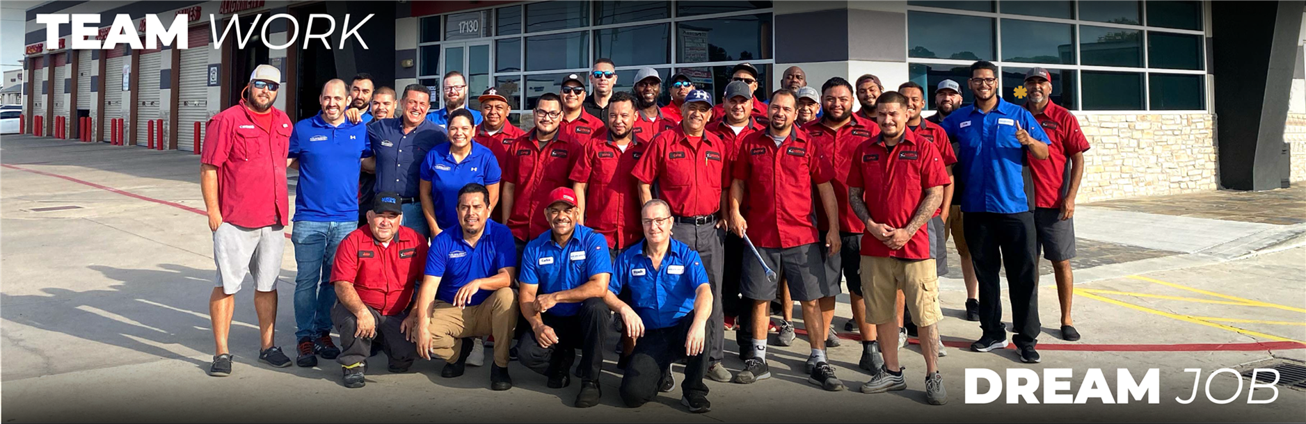 A group of people are posing for a picture in front of a building. | Elite Auto Experts