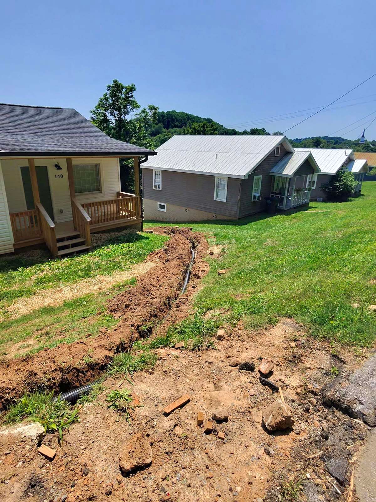 A couple of houses sitting next to each other on a lush green field.