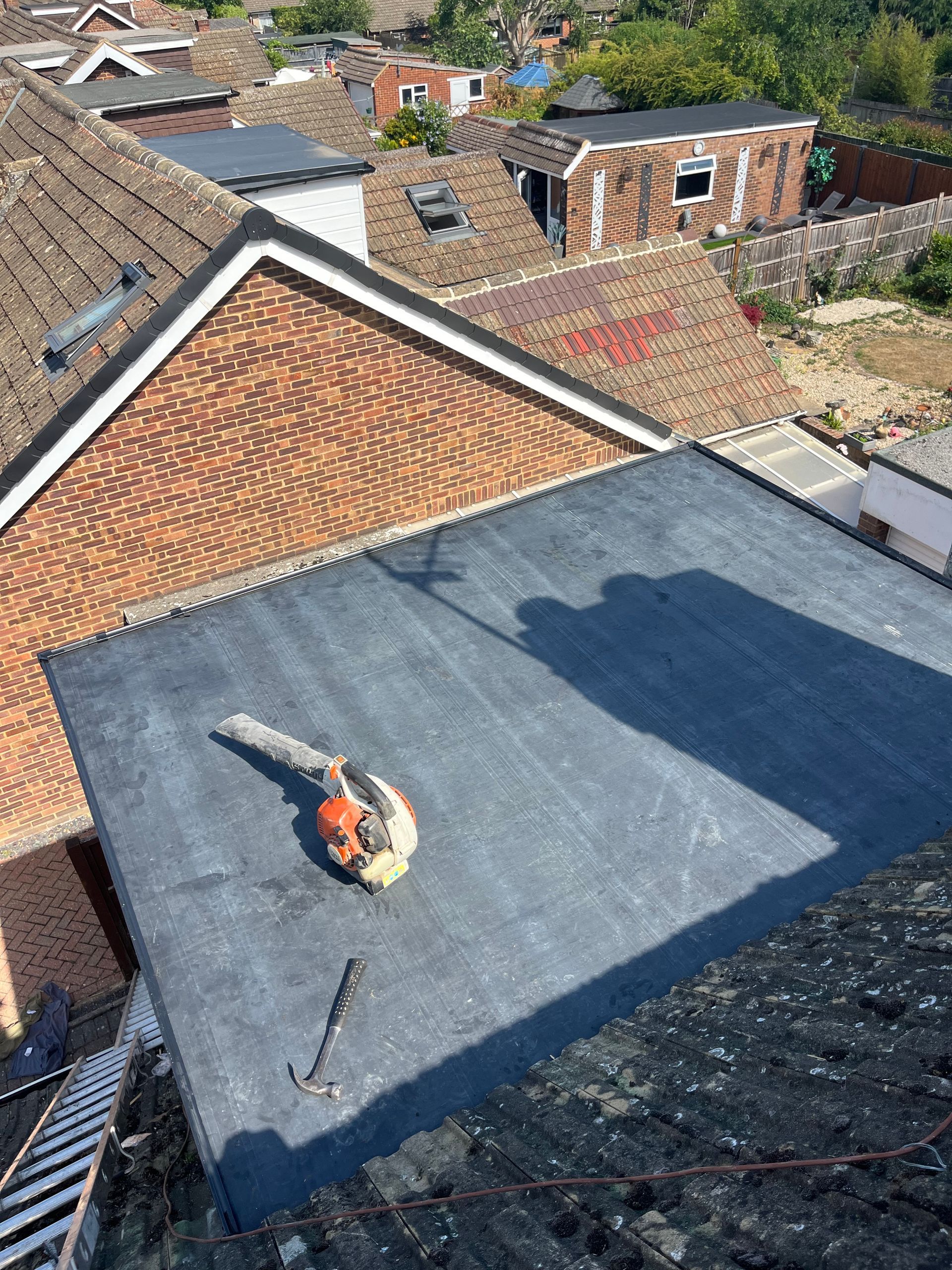 A man is laying on the roof of a house.