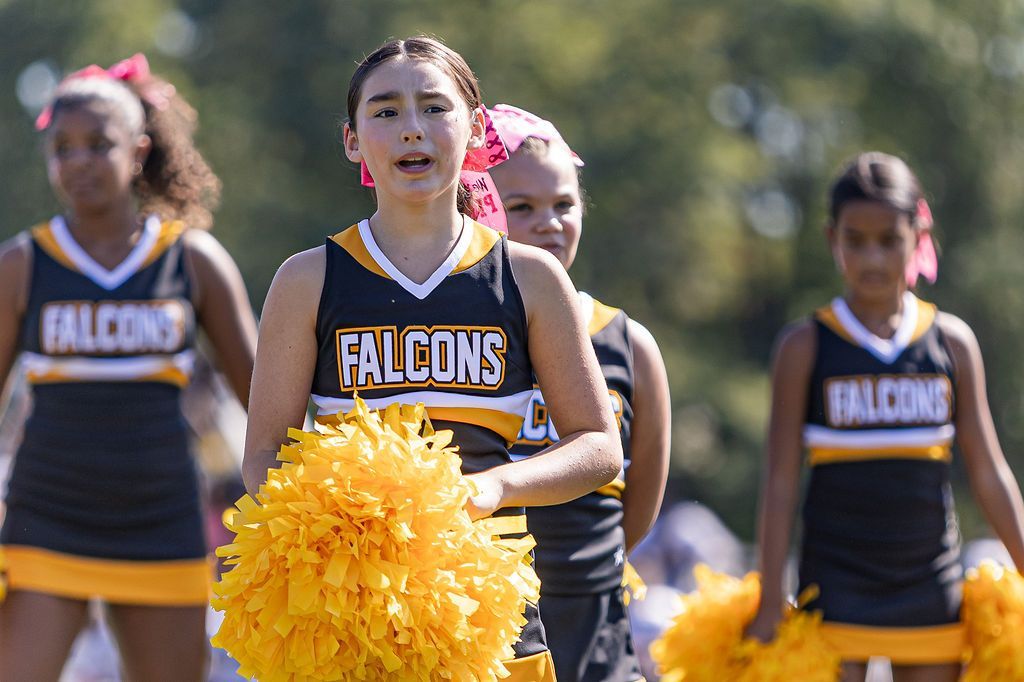 Red, white, and blue pom-poms held high by cheerleaders during a performance.
