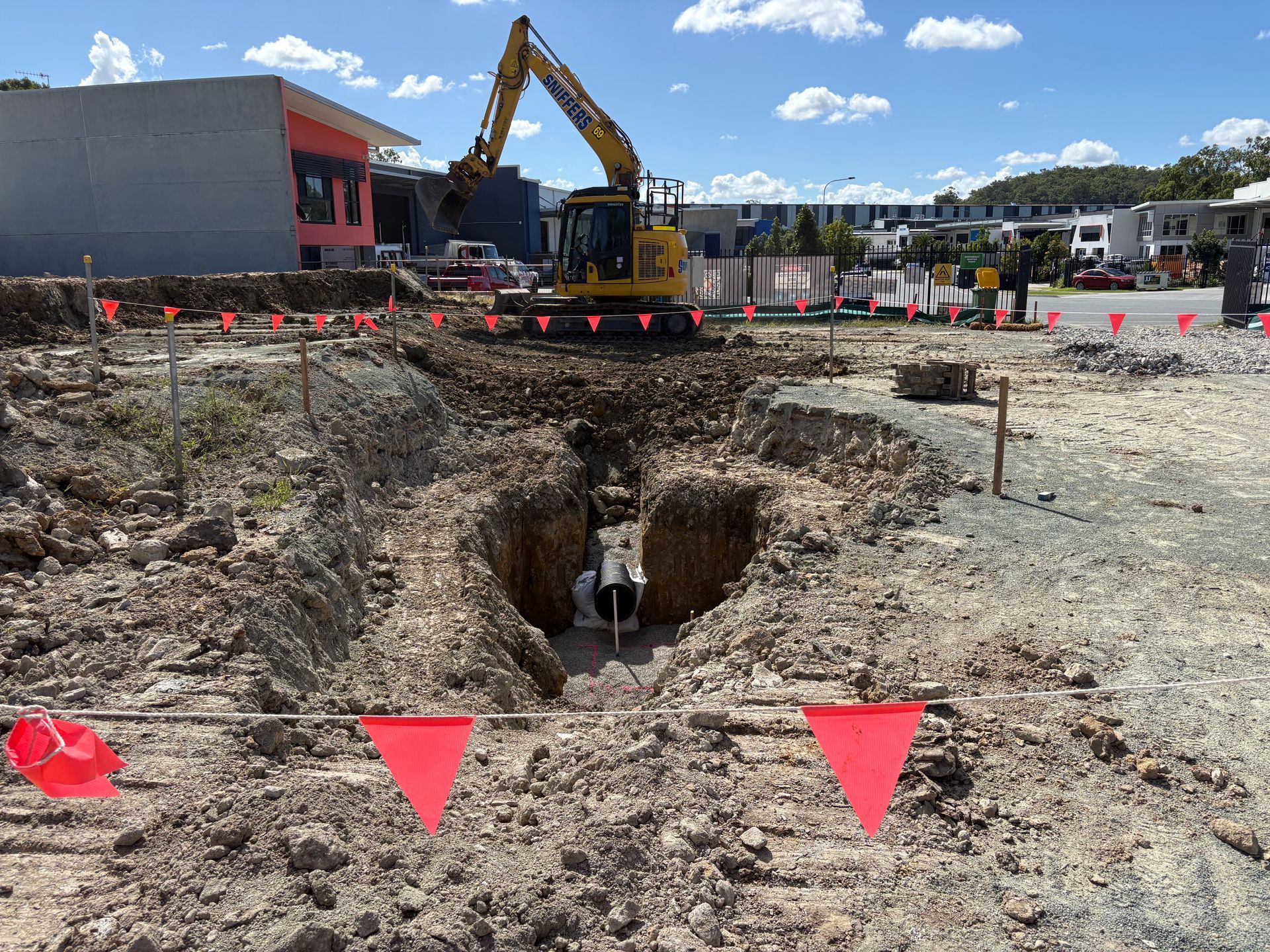 A yellow excavator is digging a hole in the ground
