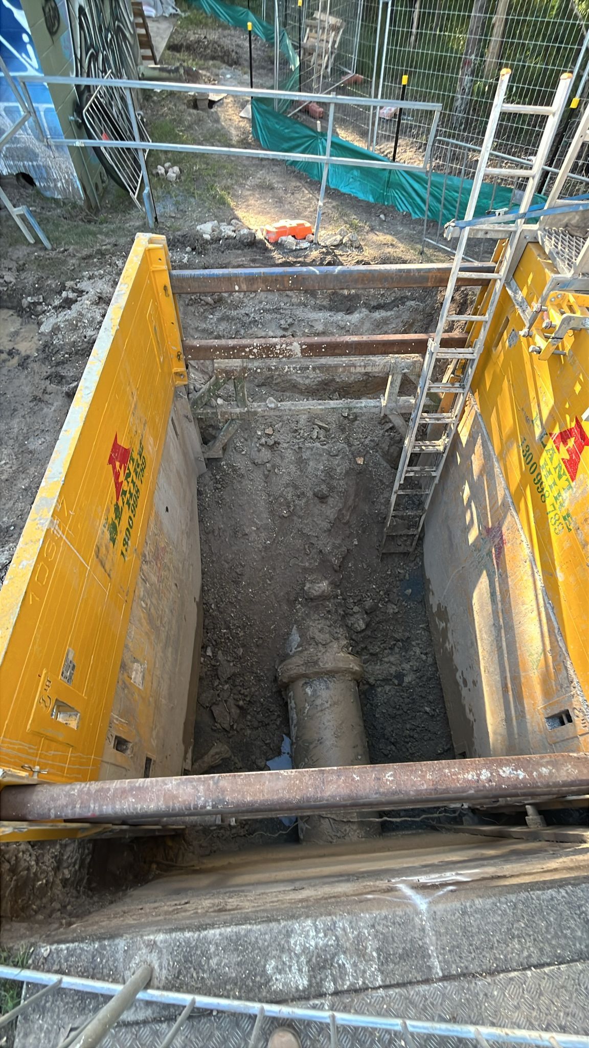 A large pipe is being installed in a trench.