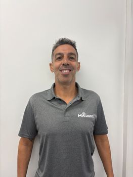 A man in a white shirt is smiling for the camera.