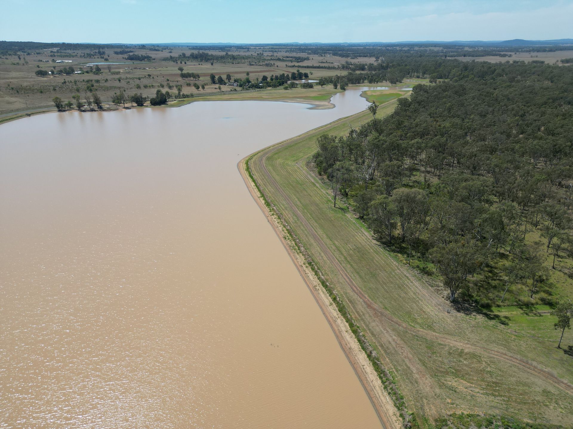 An aerial view of a river surrounded by trees and grass.