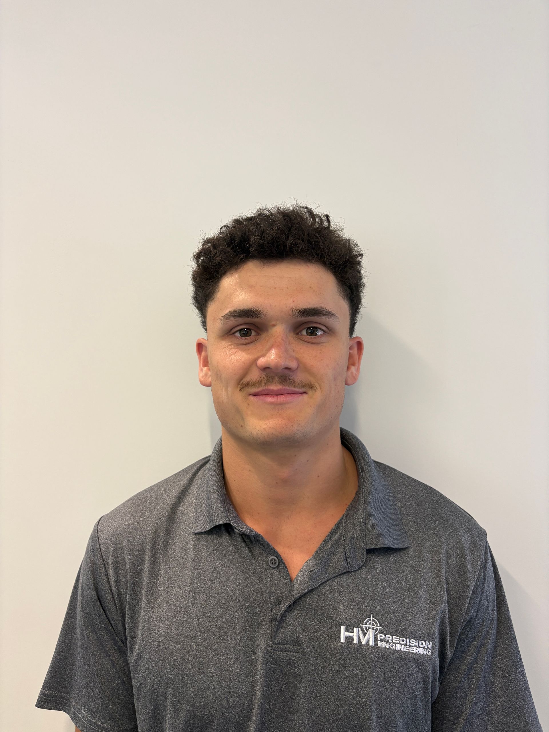 A man in a white shirt is smiling for the camera.