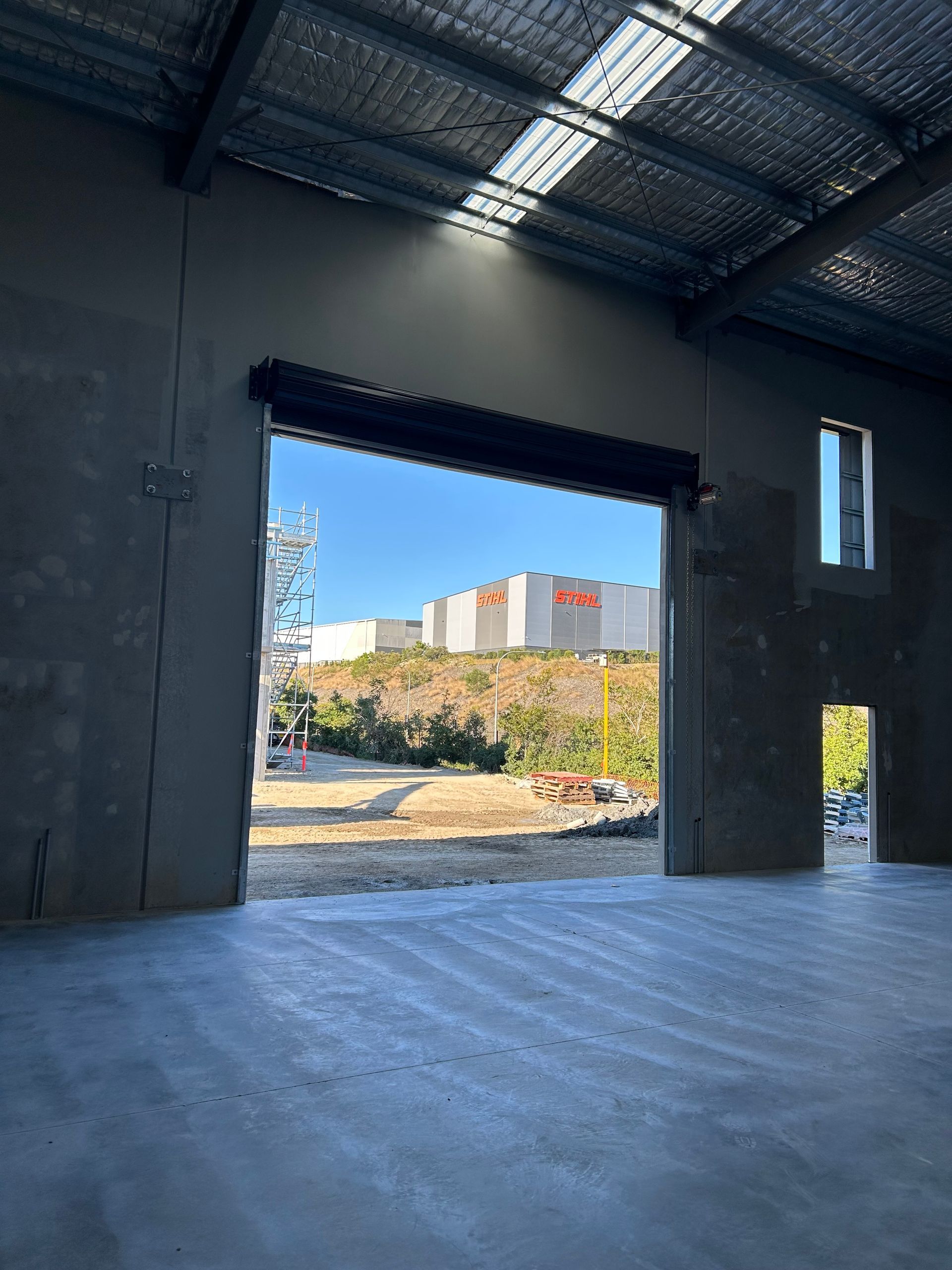 An empty warehouse with a large garage door open.