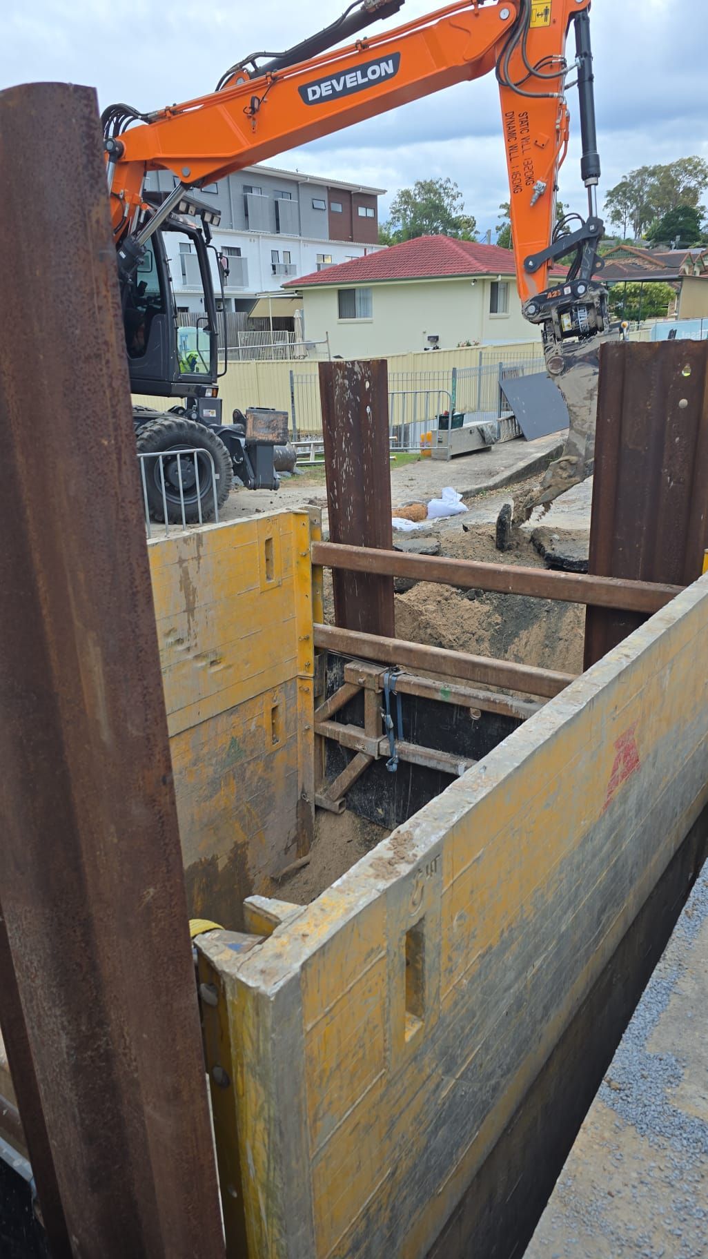 A large orange excavator is working on a construction site.